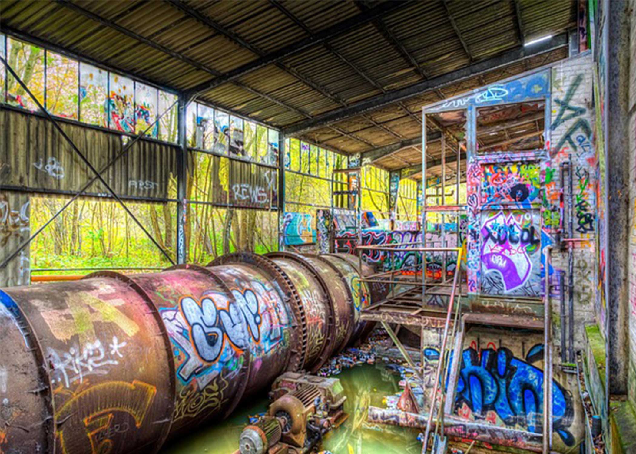 Graffiti-covered industrial pipes in an abandoned site
